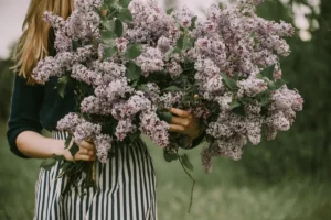 a woman holding a bunch of flowers in her hands