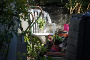 White plastic chair with plants and garden items